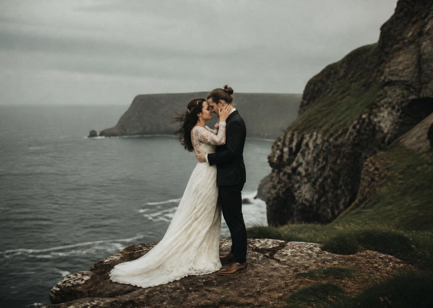 Couple eloping on a sea cliff in soft overcast light